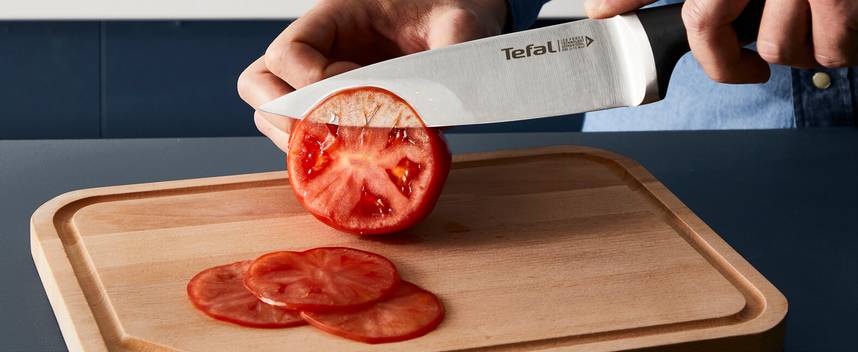 Pomidor na drewnianej desce krojony nożem Tefal