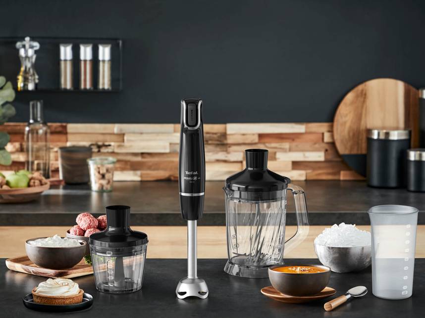 Czarny blender ręczny Tefal z dodatkowymi końcówkami stojący w kuchni